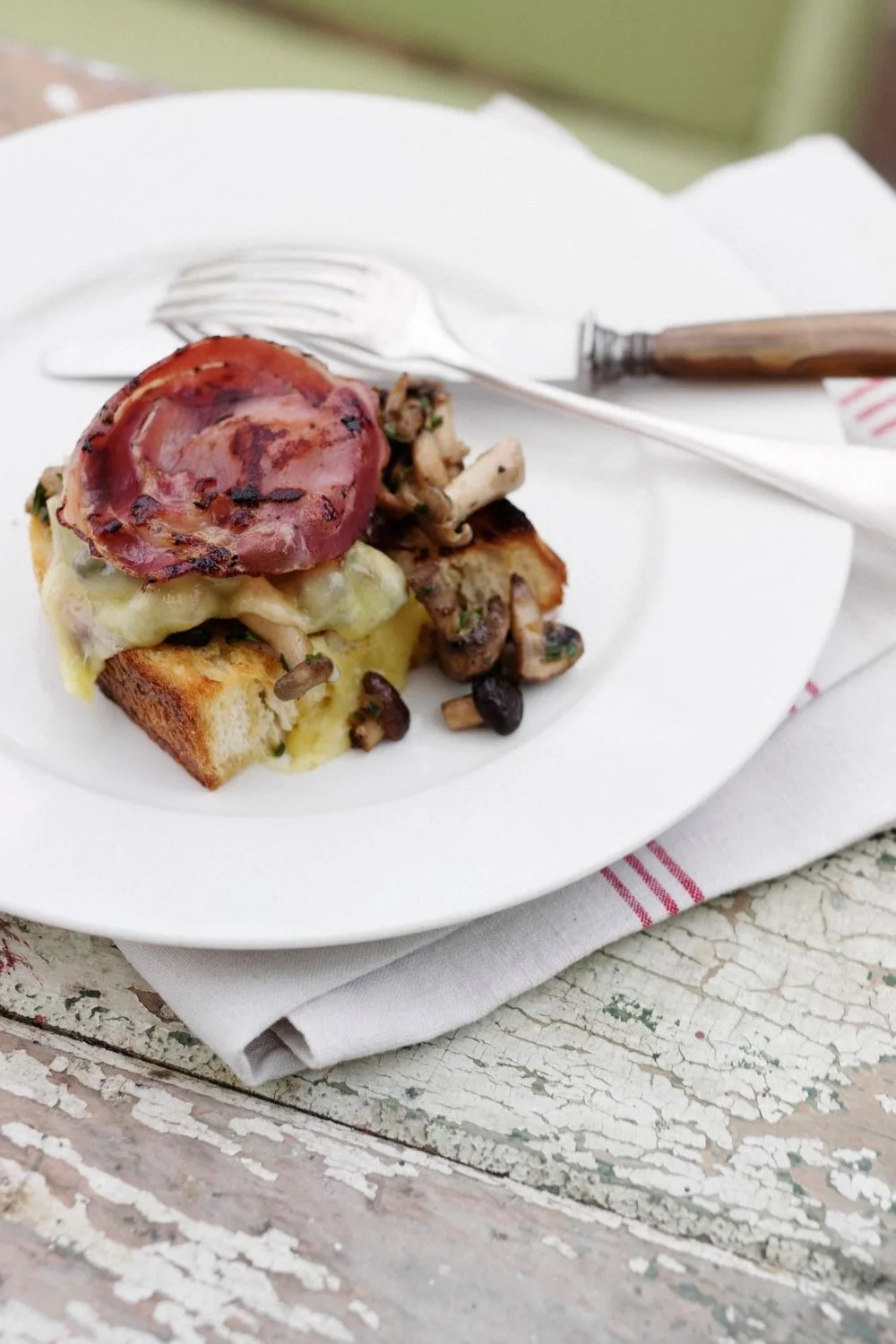 Cooked bacon on toast with cheese and mushrooms