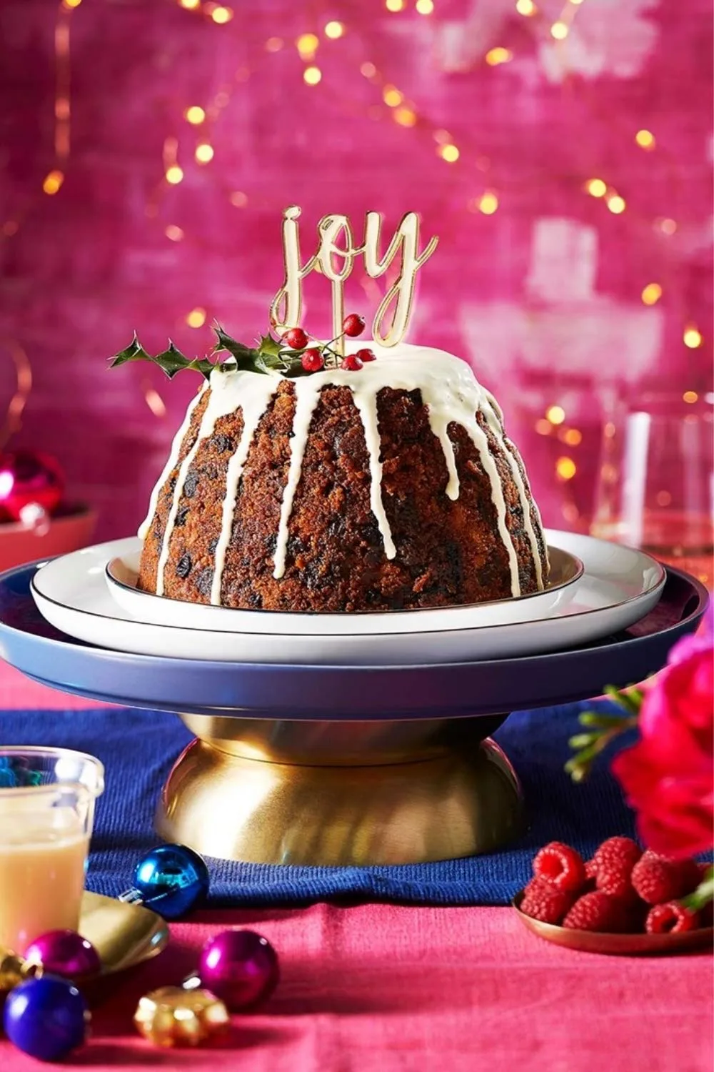 steamed pudding with dripping icing and joy decoration sticking out of the top