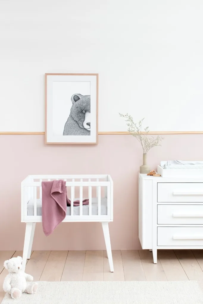 Child's nursery with white cot and black and white artwork