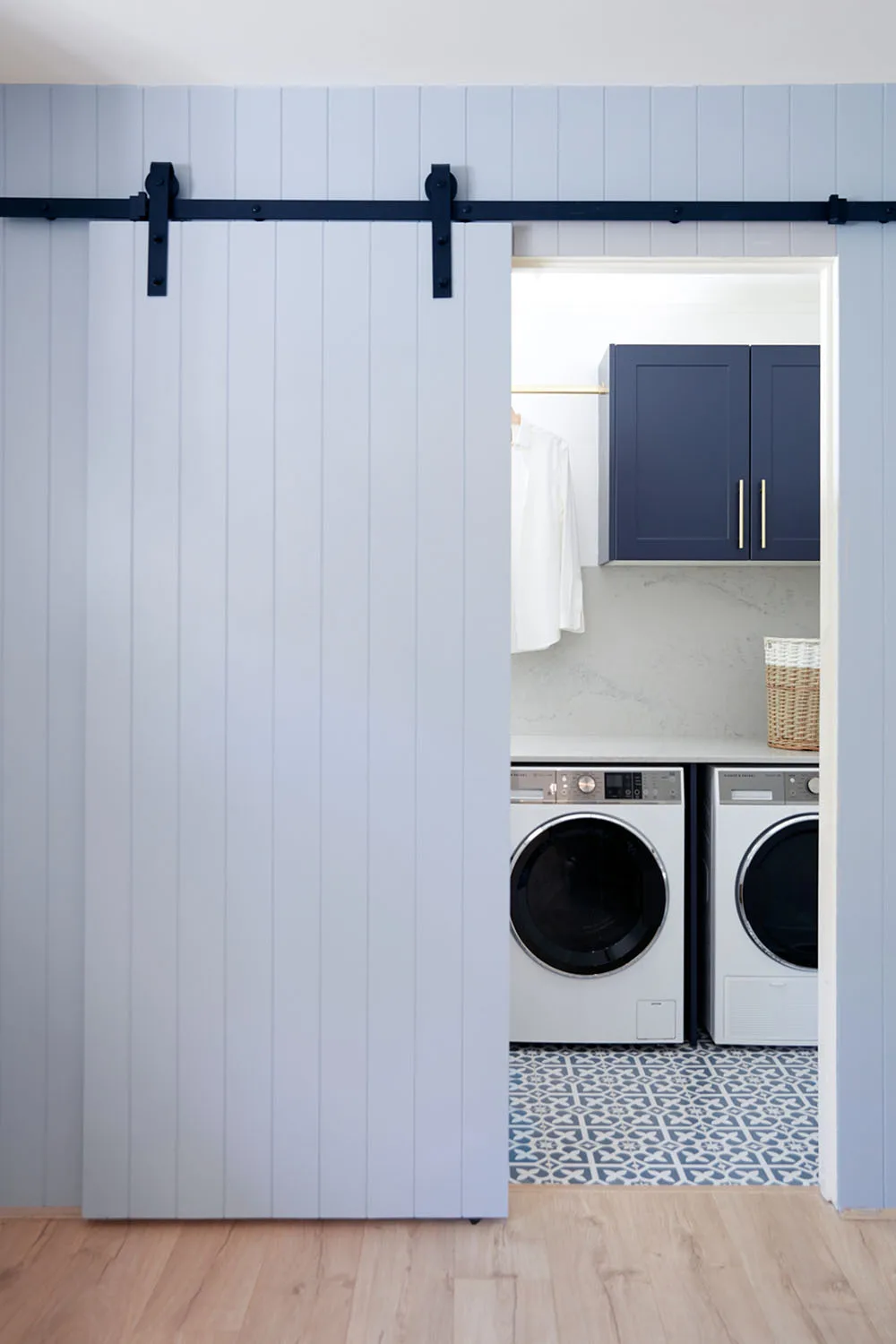 Sliding blue door opening to renovated laundry