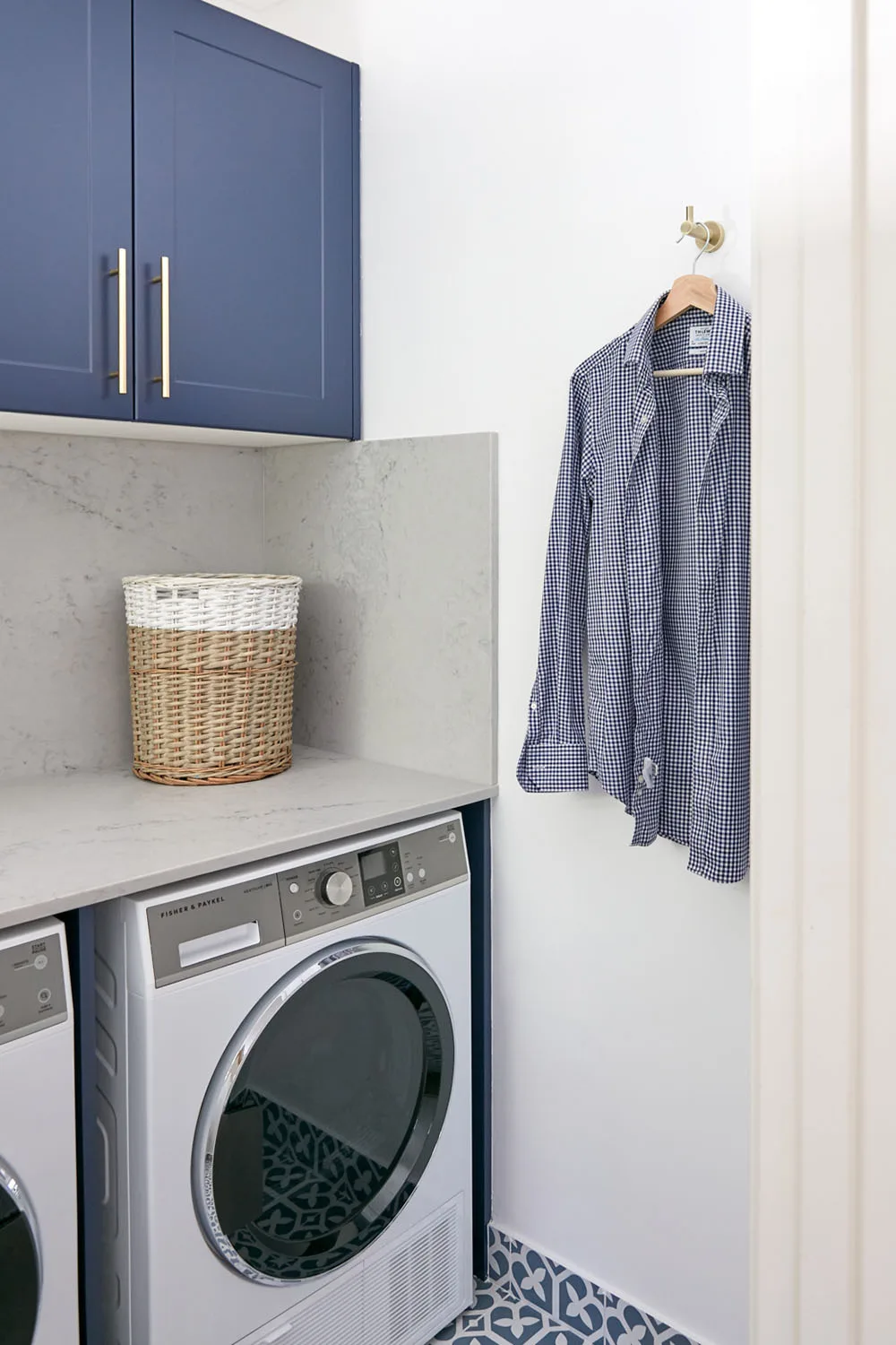 Laundry with Caesarstone splashback and navy blue cabinetry