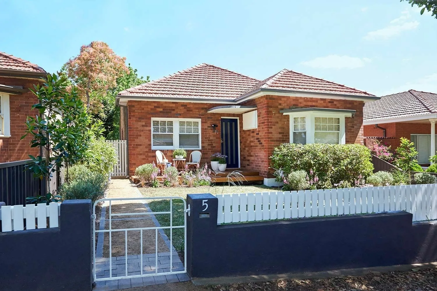 1950s style brick house with a grey fence