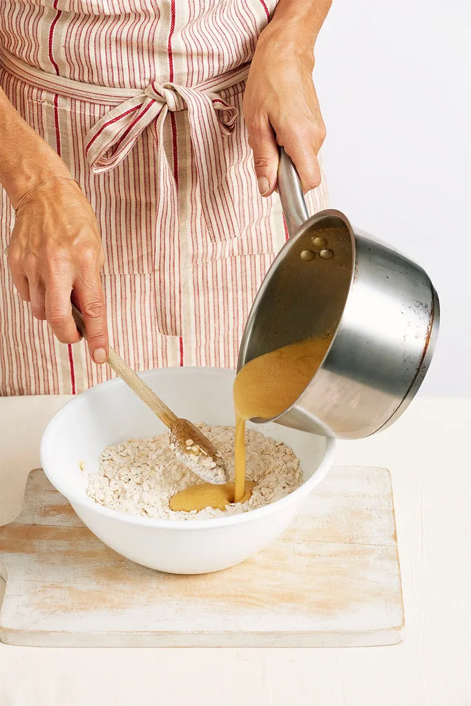 pouring wet anzac mixture into dry