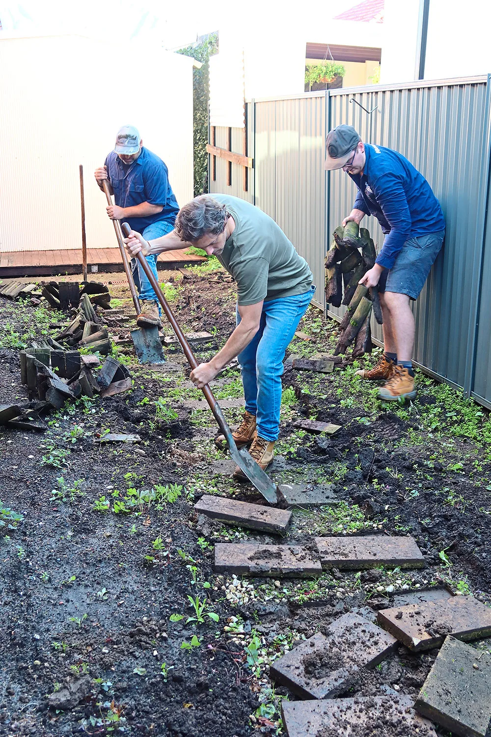 Charlie Albone removing old pavers in garden