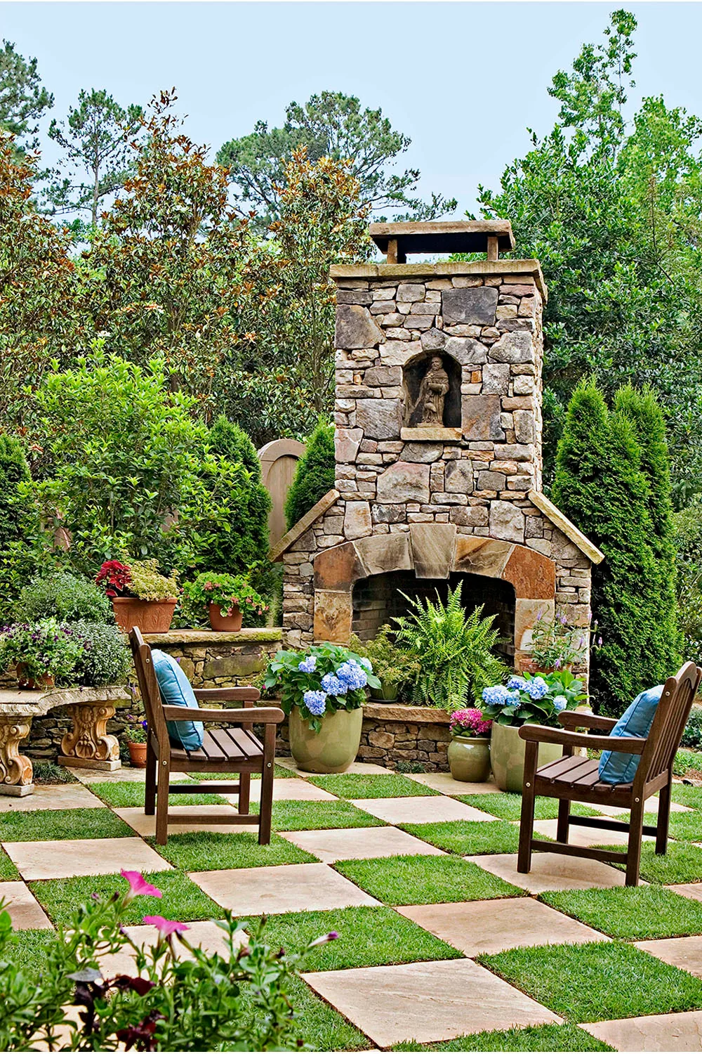 Stone outdoor fireplace with checkerboard paving