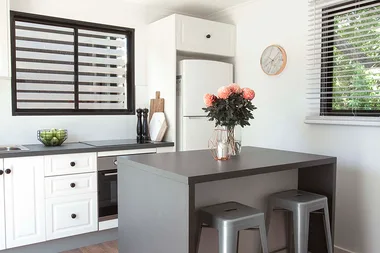 This budget galley kitchen features a genius portable island bench