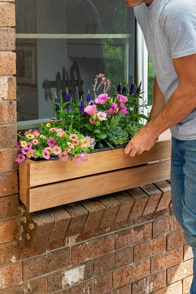 Charlie Albone installing a DIY timber window planter box to a brick window ledge