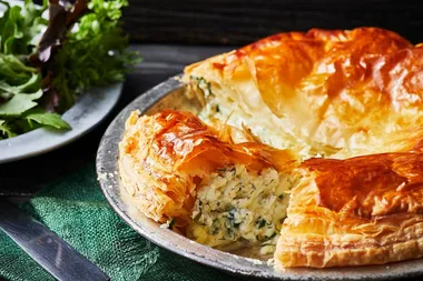 Cheese and herb pie with a side salad in the background