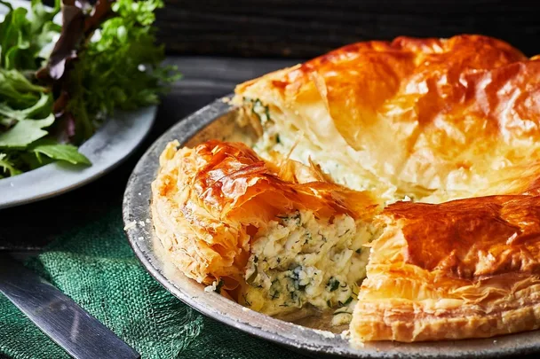 Cheese and herb pie with a side salad in the background