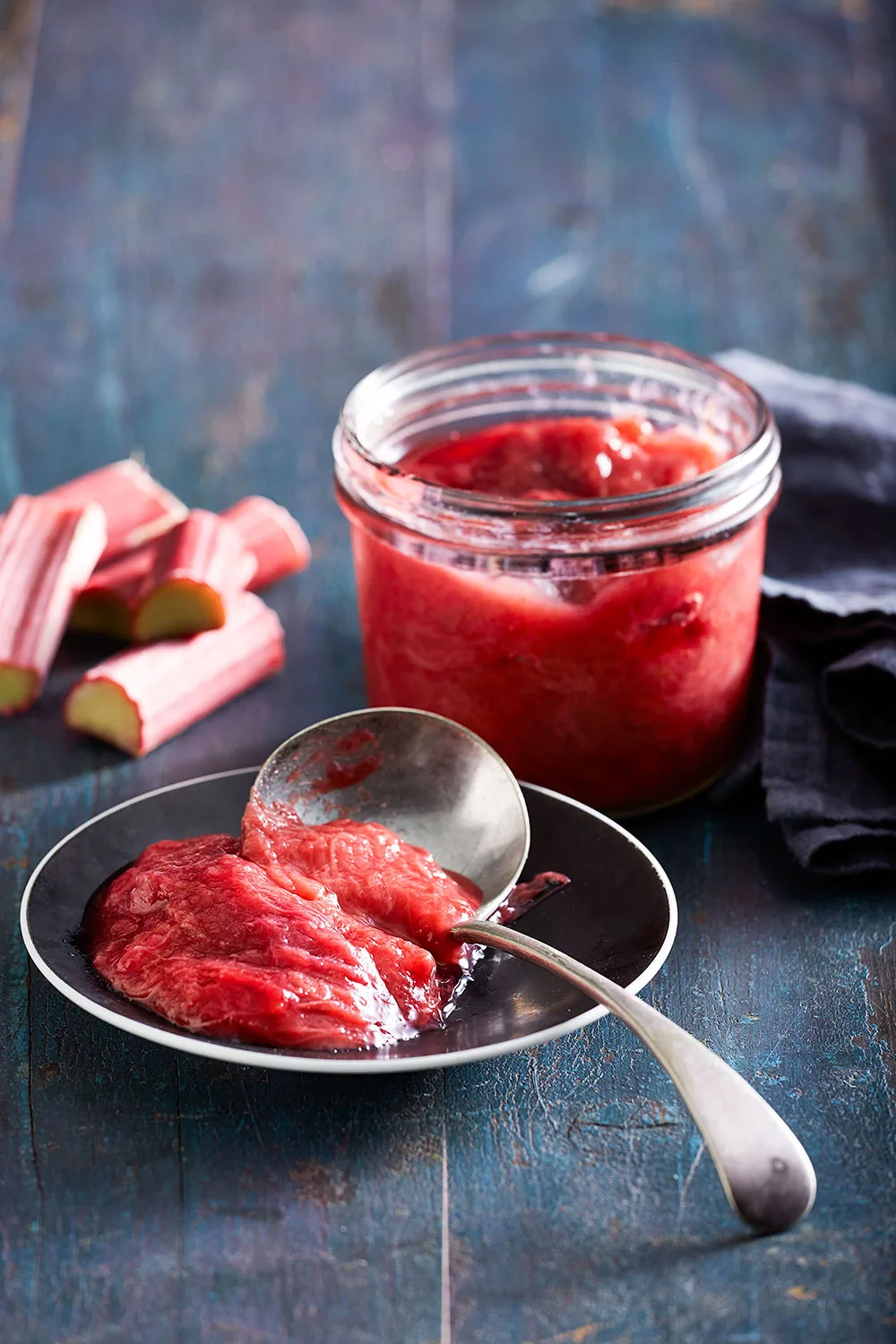 stewed rhubarb on plate with ladle and pot of stew behind it