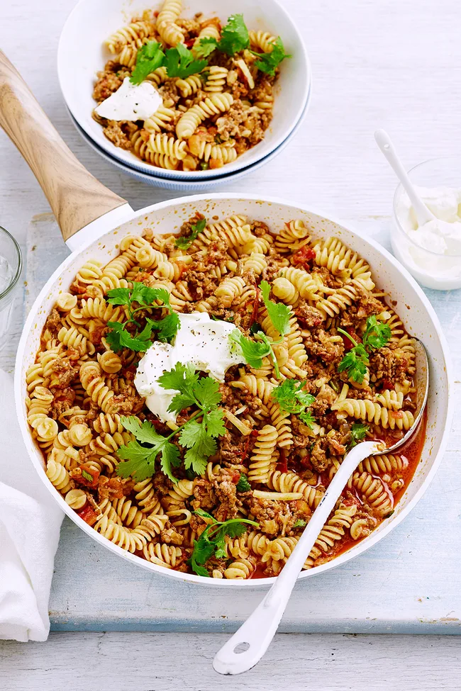 taco spiral pasta with dollop of sour cream and parsley