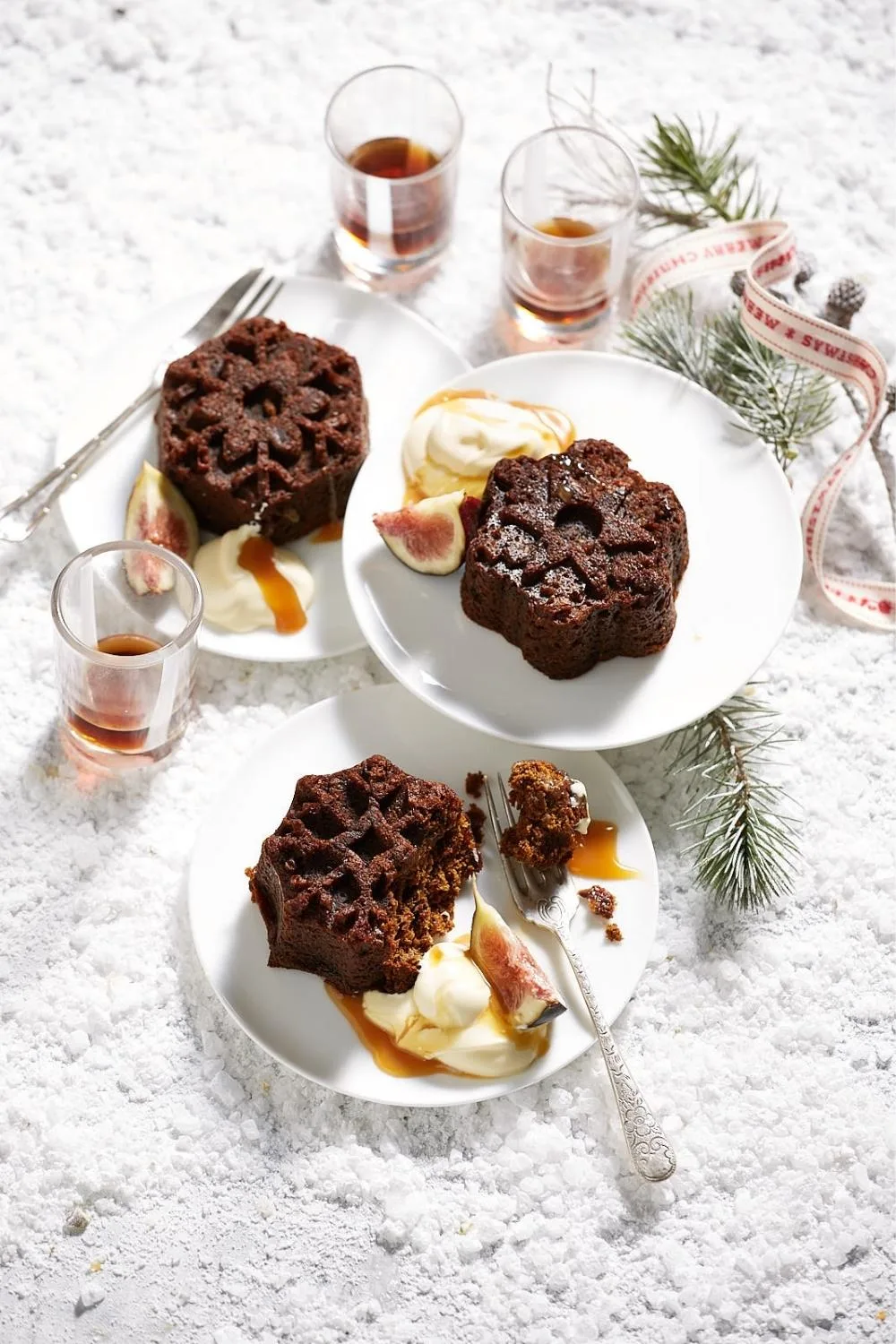 Coffee and fig fruit cakes on dessert plates with icecream and a fig on the side