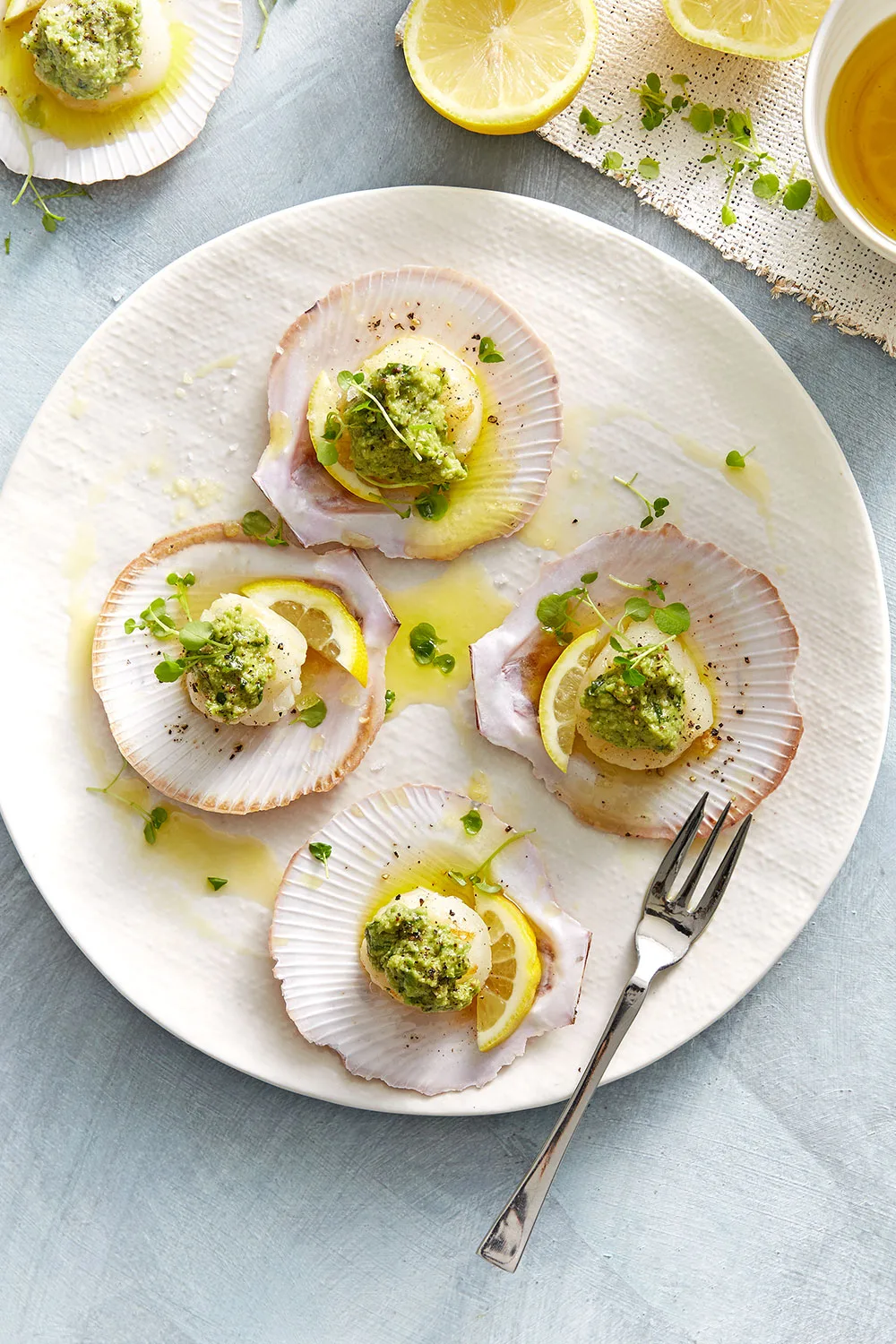 Seared scallops in shells with green olive tapenade