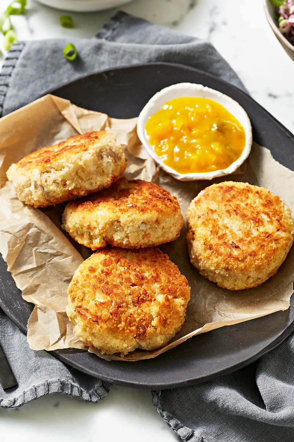 Pork and potato fritters with relish on the side on top of baking paper