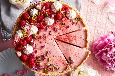 raspberry rhubarb mousse cake with two slices cut into it and a blobbed icing topping