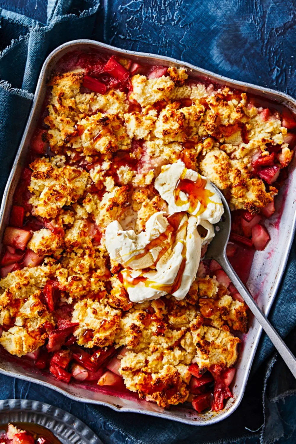 gluten-free crumble with pink fruit and ice cream dollop and syrup on spoon