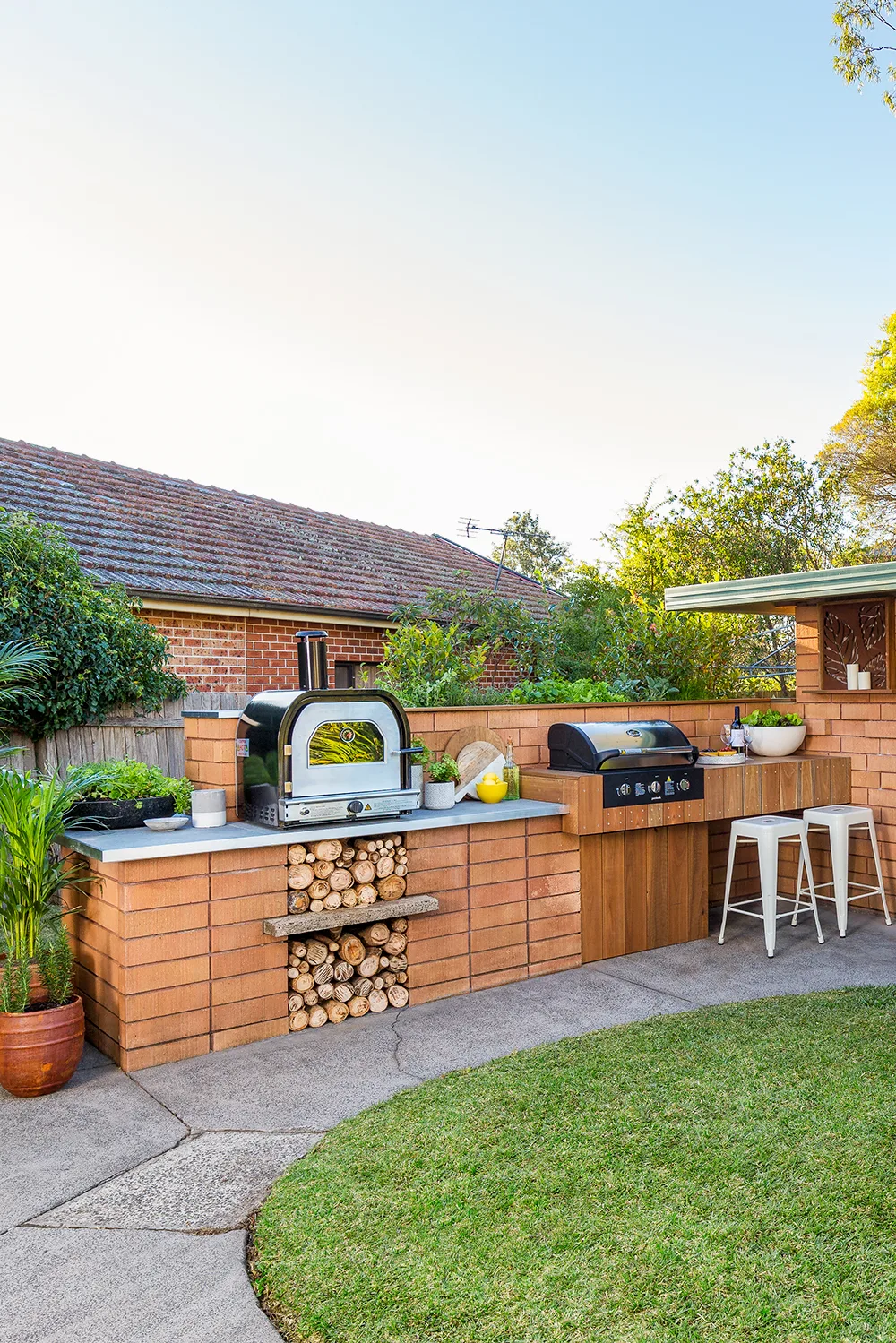 Brick barbecue area with a pizza oven and wood storage area