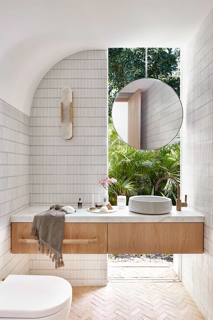 Bathroom with large window and round mirror