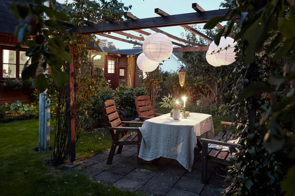 A simple arbor and some ambient lighting set a cosy scene outdoors.