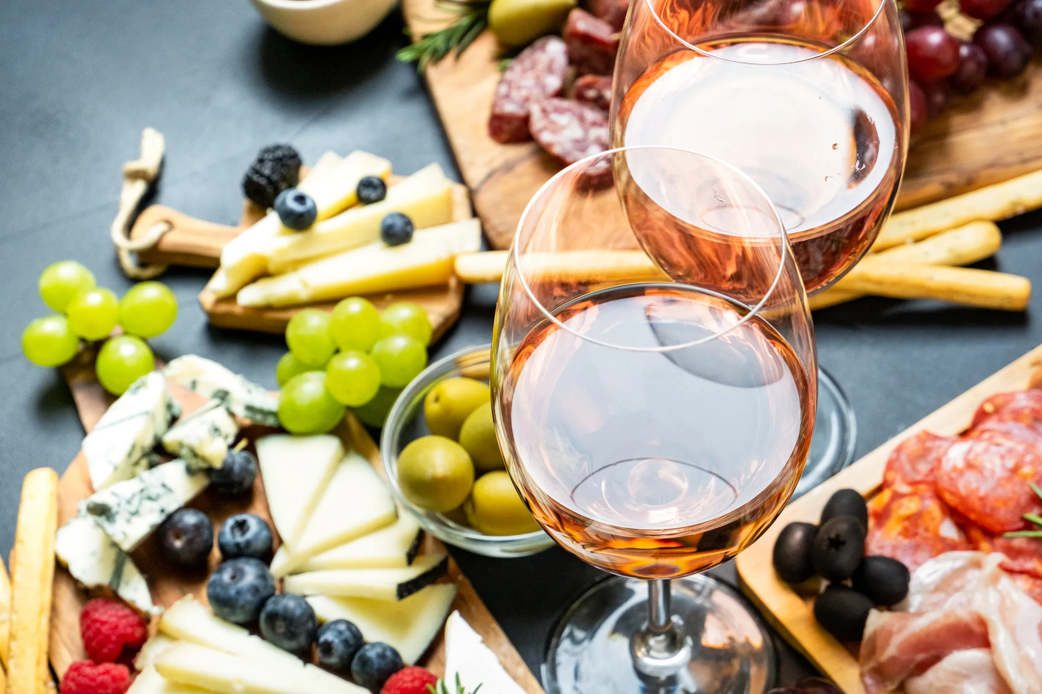 A cheese board with glasses of rose wine.