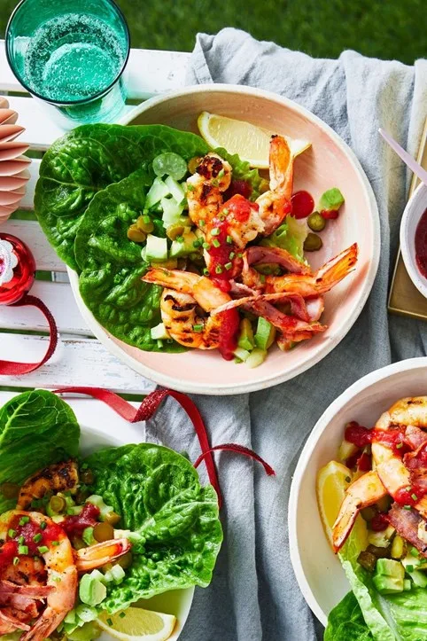 bloody mary king prawn cocktails with lettuce and lemon wedge in pink bowl