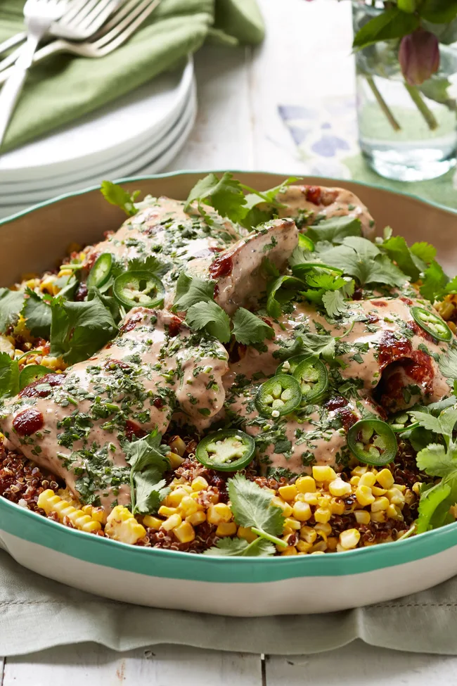 chicken and quinoa salad in green bowl with corn