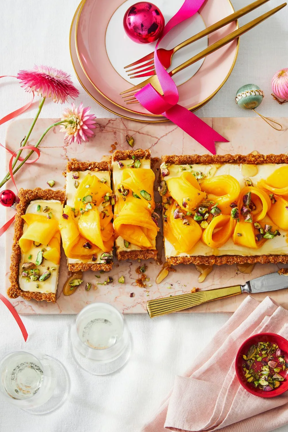 ginger-mango-cheesecake in long log with mango strips on top and christmas tablescape 