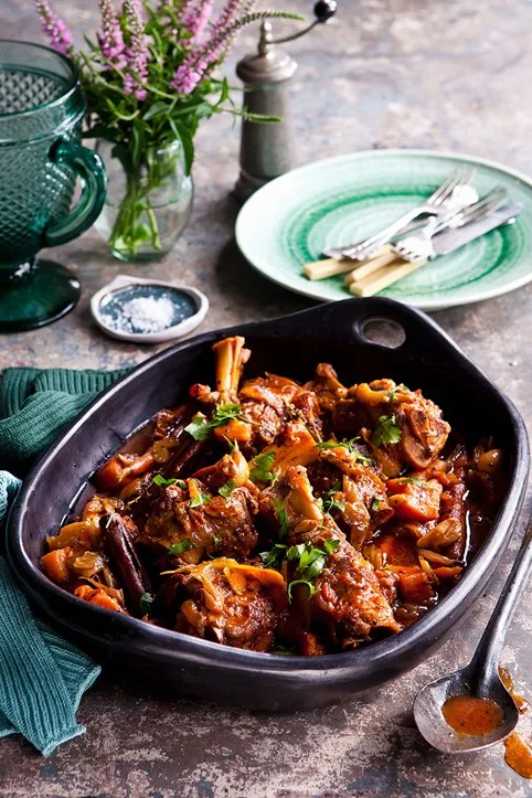 slow cooked lamb shanks in black bowl with bones still in