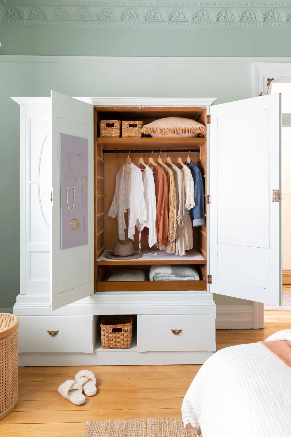 wardrobe open filled with clothing jewellery hanger on door