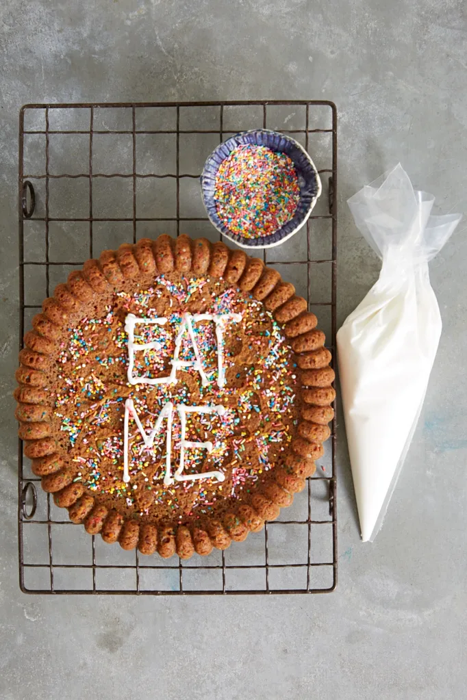 giant choc chip cookie on cooling tray with eat me in writing