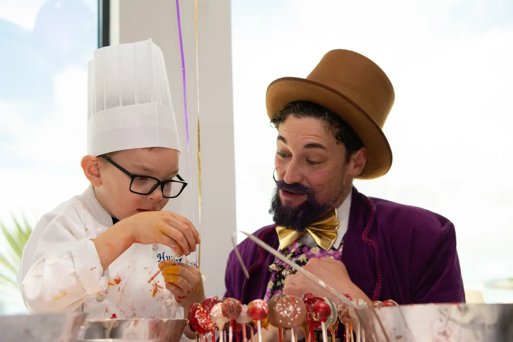 Photo of young boy making desserts alongside Willy Wonka