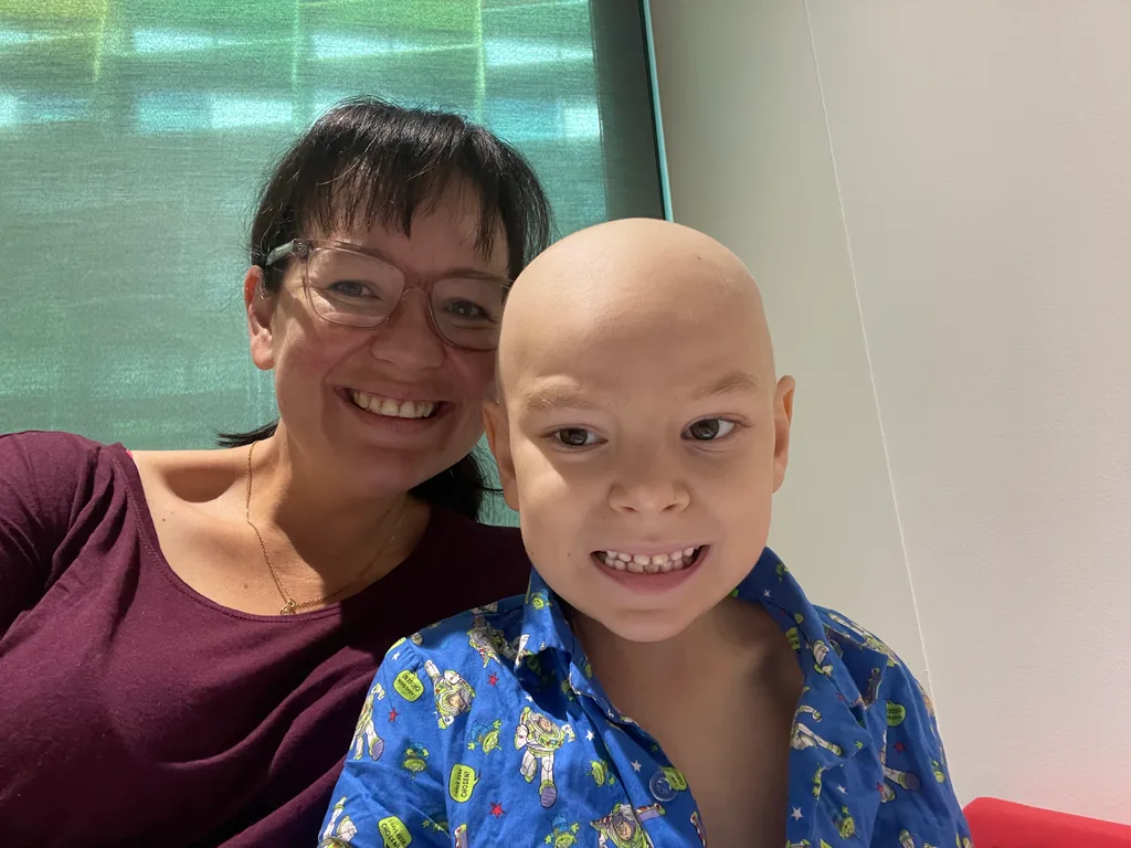 Photo of mum and son in hospital shortly after losing hair to chemo