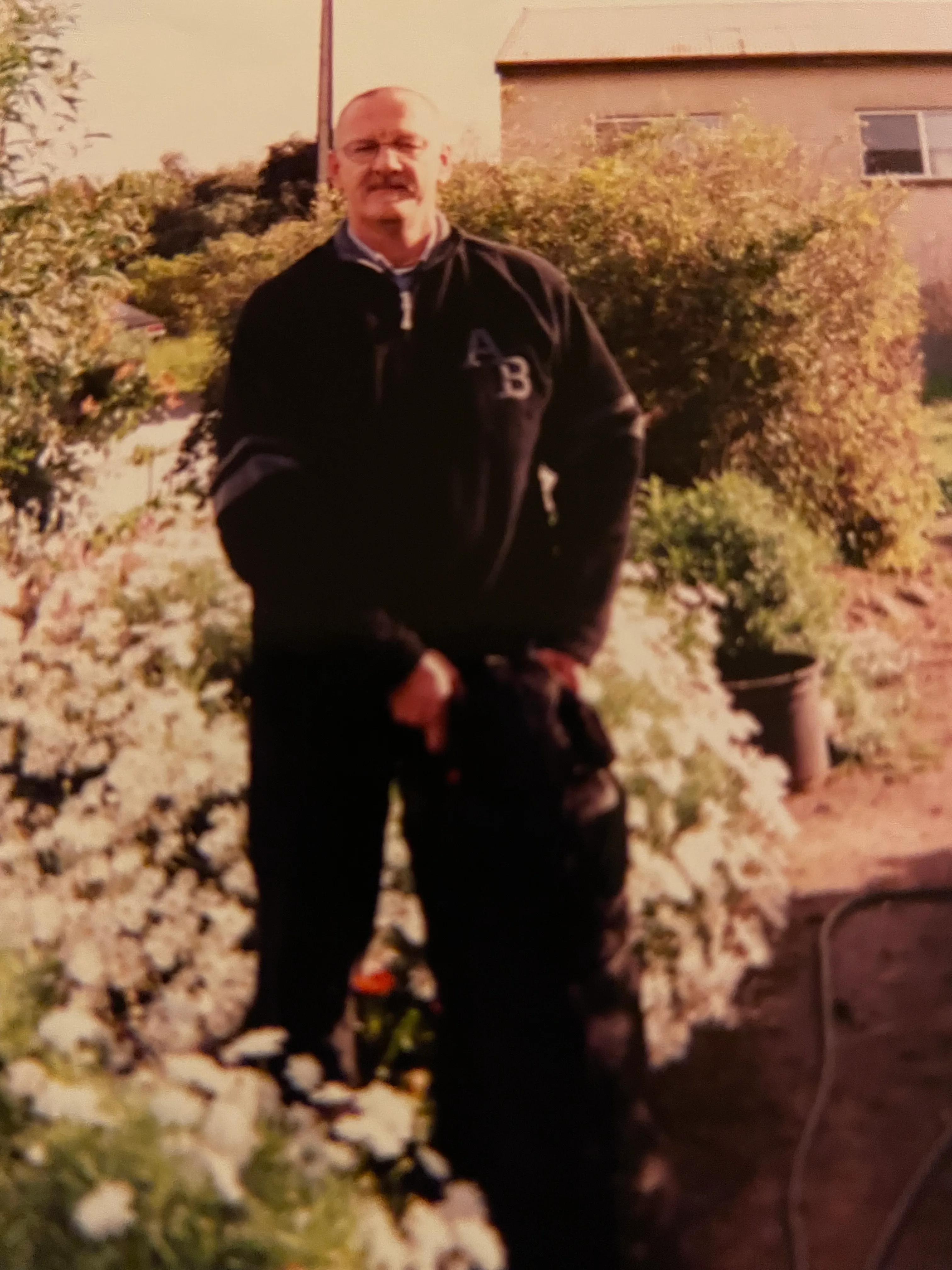 Photo of man and dog standing in the garden