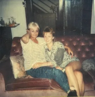 girl with woman pointing sat on sofa
