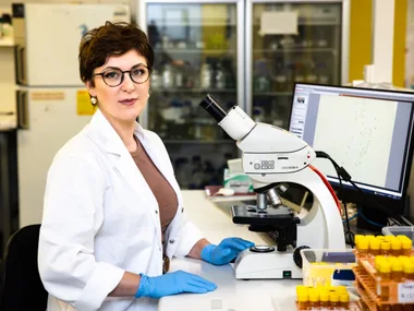 Woman Paola Magni sat in lab with a microscope