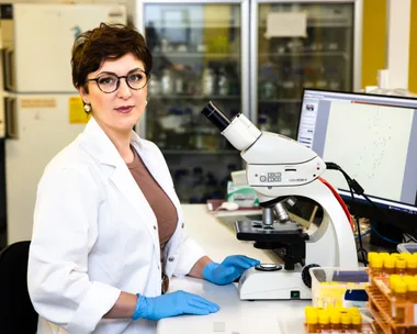 Woman Paola Magni sat in lab with a microscope