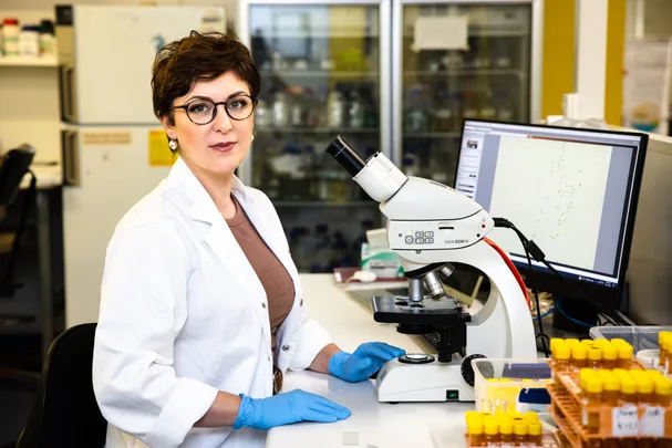 Woman Paola Magni sat in lab with a microscope