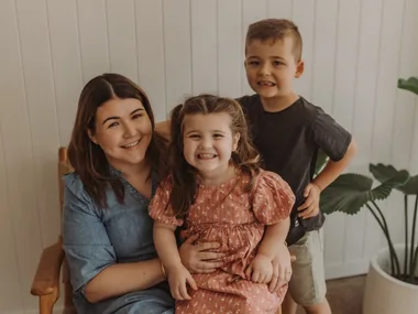 Woman and two children seated and smiling