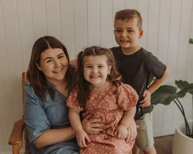 Woman and two children seated and smiling