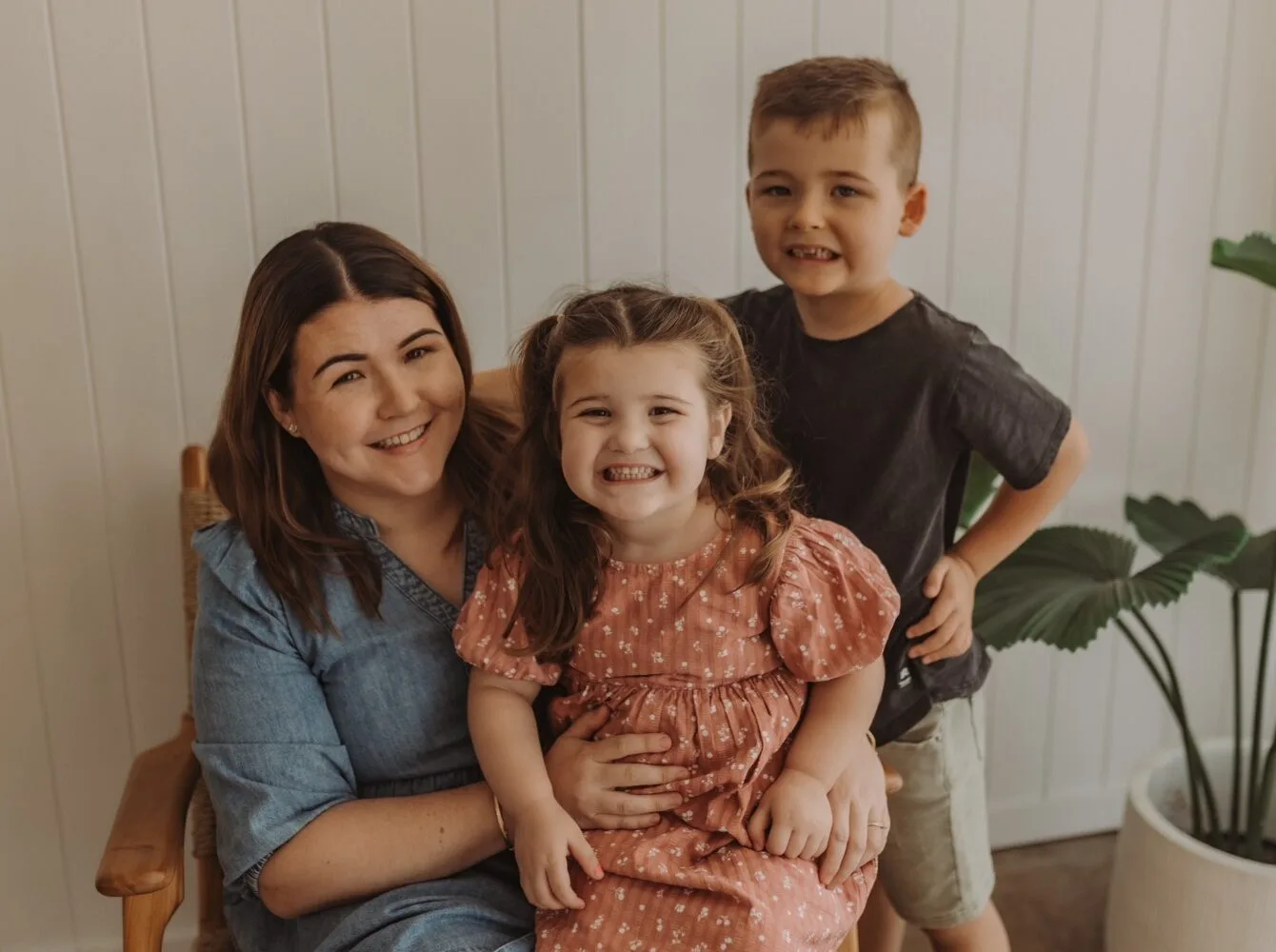 Woman and two children seated and smiling