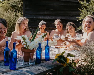 Image of women sitting around a table in the nude