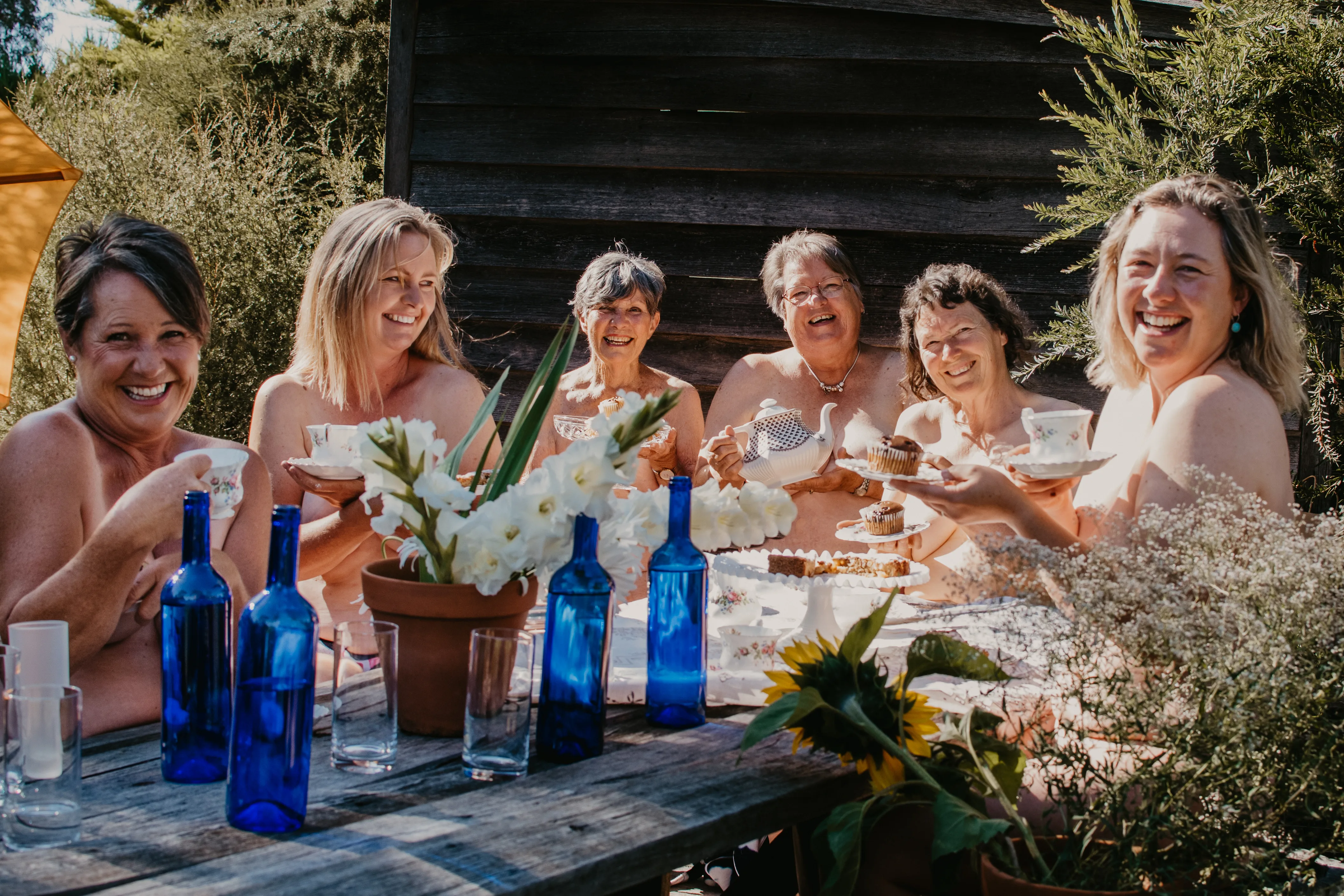 Image of women sitting around a table in the nude