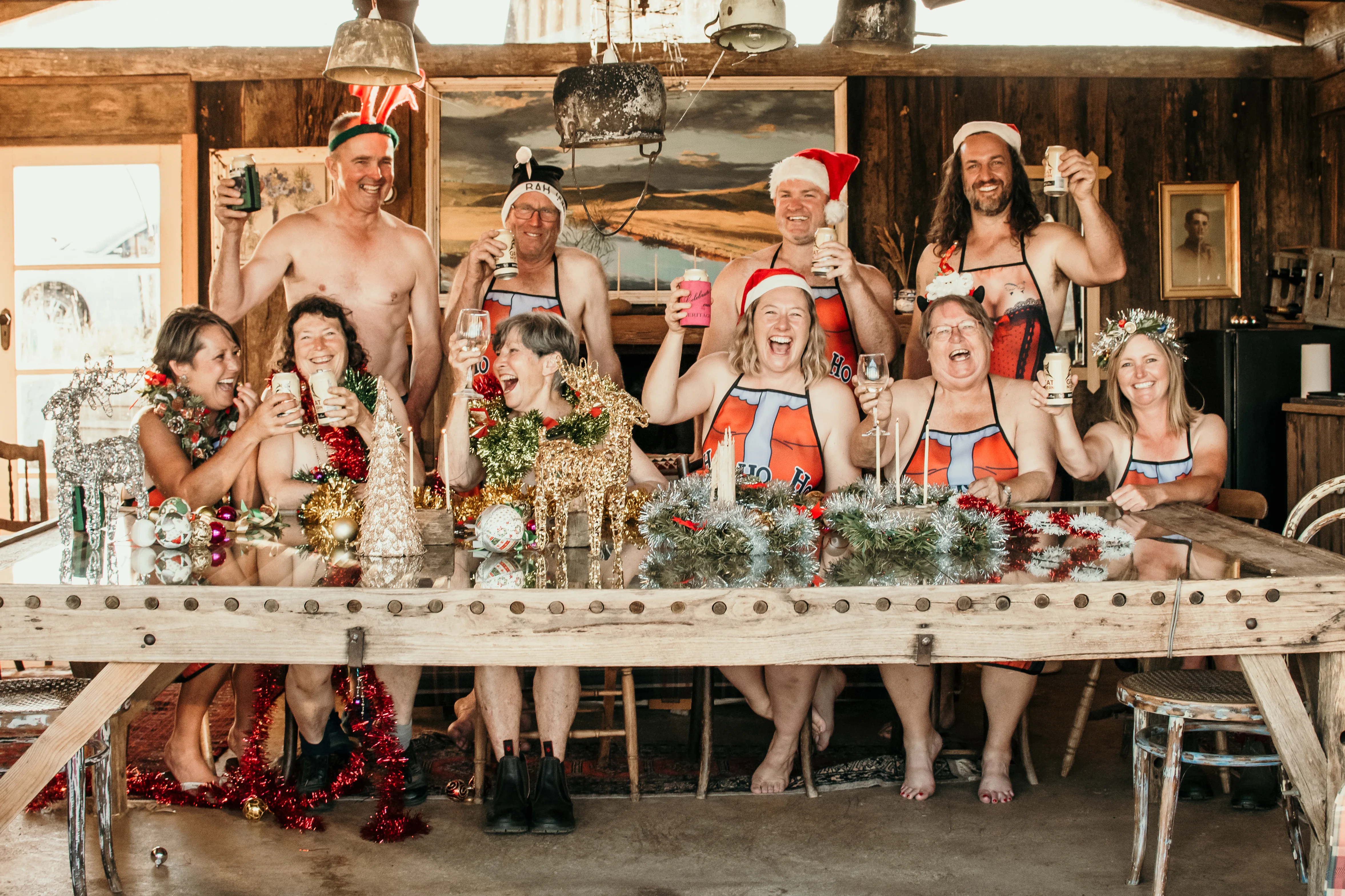 Image of men and women standing in the nude wearing santa hats