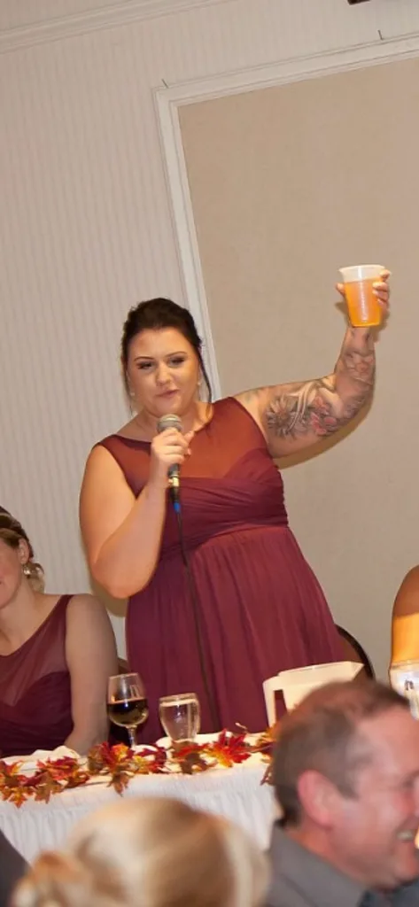 Ali wearing red dress and holding a beer