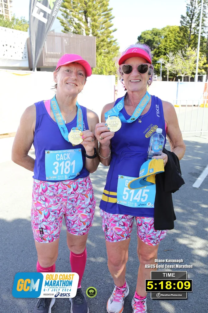 Image of two women holding their marathon medals