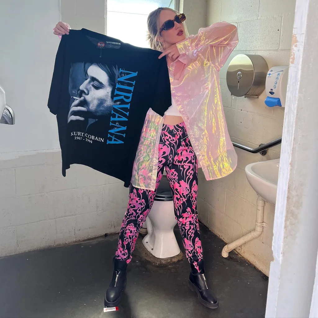 Image of woman holding vintage band tee from the thrift store