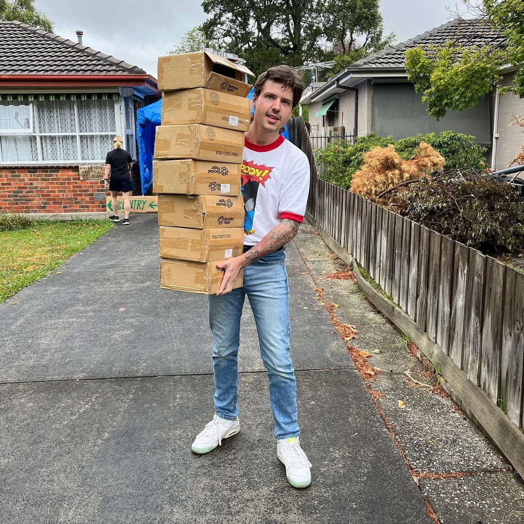 Image of man holding boxes of goods from a garage sale