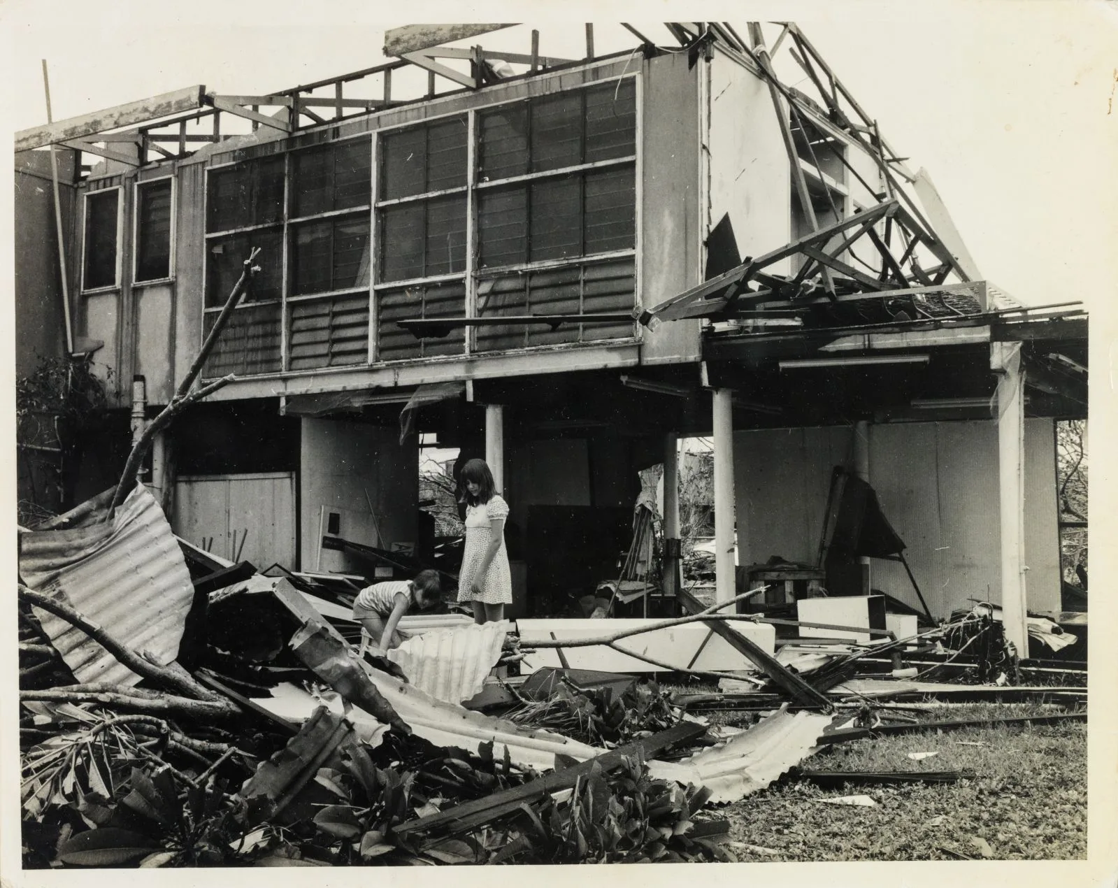 Ruins of demolished house with two girls 