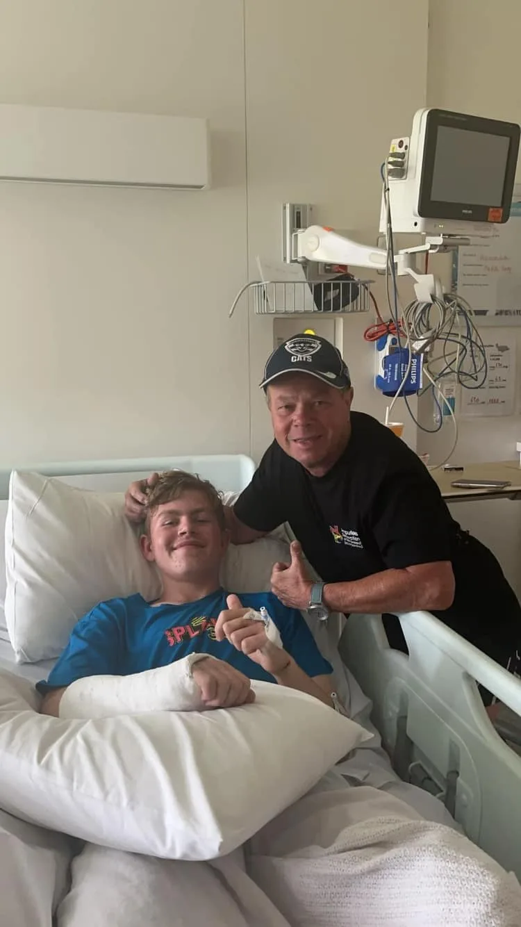 Geoff visiting his grandson in hospital. The pair are both giving a thumbs up to the camera