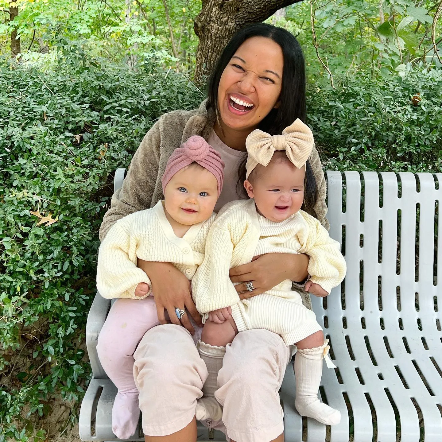 A woman holding two baby girls